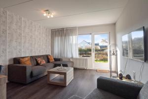 a living room with a couch and a table at Beach Appartement 14 - Aan de duinen, Callantsoog aan Zee in Callantsoog