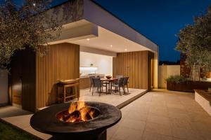 eine Feuerstelle in der Mitte einer Terrasse in der Unterkunft Apartments Villa Pliško Wellness & Pool in Fažana
