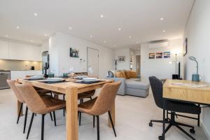 a kitchen and living room with a wooden table and chairs at Sunset View Apartment in Conceicao de Tavira in Tavira
