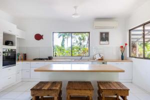 MialloにあるRainforest Retreat in Bambooの大きな島(木製のスツール2脚付)のあるキッチン