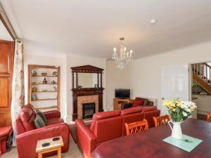 a living room with red furniture and a fireplace at Mayfield Manor in Whitby