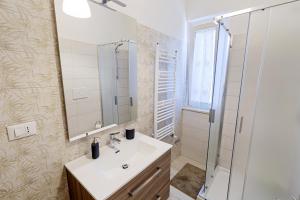 Un baño blanco con lavabo y ducha. en Colibrì Apartament, en Lanciano