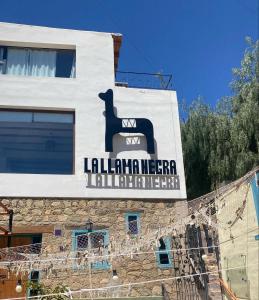 a sign on the side of a building at La Llama Negra in Tilcara