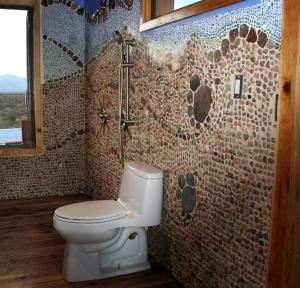 ein Badezimmer mit einem WC und einer Mosaikwand in der Unterkunft Secluded Glamping Eco-Pod Rental in the Mojave Desert near Ridgecrest, California in Ridgecrest