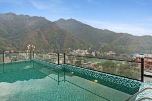 a swimming pool with a view of a mountain at ZANA by the Ganges, Tapovan, Rishikesh in Rishīkesh