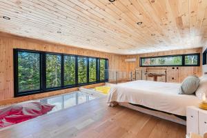 a bedroom with a large bed and a swimming pool at Chillwood - Sauna & Cold Plunge - Hammock Beds in Notre-Dame-de-la-Merci