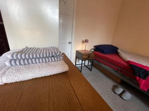 a bedroom with a bed and a table with a lamp at Single room 10 minutes to Central London in London