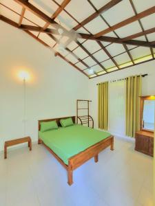 1 dormitorio con cama verde y techo en Serene Lush Holiday Home, en Tangalle 21 fotos más