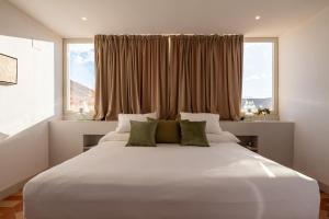 a large white bed in a room with a window at Palacio de los Leones in Lora del Río +98 photos