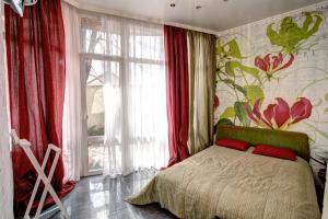 une chambre avec un lit avec une fresque florale sur le mur dans l'établissement Мarine apartments, à Odessa