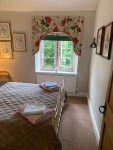 una camera da letto con un letto davanti a una finestra di Tiesel & Truffles Cottages a Cheltenham
