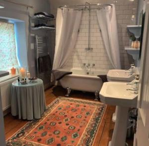 un bagno con vasca, WC e lavandino di Tiesel & Truffles Cottages a Cheltenham Altre 90 foto