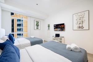 a bedroom with two beds and a desk at Prime Location - 2BR with Spectacular Sea View in Dubai