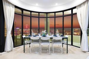 a dining room with a table and chairs in front of a window at Prime Location - 2BR with Spectacular Sea View in Dubai