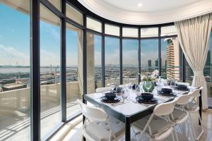 a dining room with a table and chairs and glass windows at Prime Location - 2BR with Spectacular Sea View in Dubai