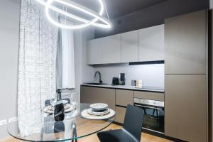 a kitchen with a glass table and chairs in a room at Unique design 200 steps from the Aquarium in Genova
