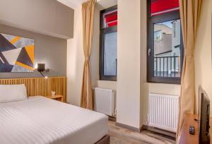 a bedroom with a bed and two windows at Hotel Forty One in Bucharest