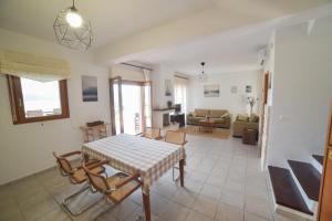 a dining room and living room with a table and chairs at Sea View Maria in Fourka