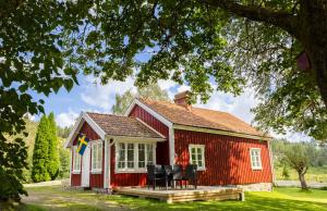 a red barn with black chairs in front of it at Grandma's cottage in Tanum