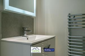 a bathroom with a white sink and a mirror at Executive Apartment Close to Station in Hatfield