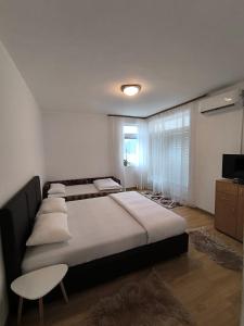 a bedroom with a large bed with pillows and a window at Apartment ONE in Plužine