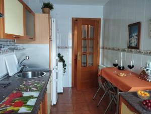 a kitchen with a sink and a table with wine glasses at El Mirador del Esla in Villanueva de las Manzanas
