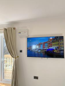 a flat screen tv hanging on a wall at Kaoglen - Alpine Pod - Hot Tub - Cairngorms - Pitlochry in Kirkmichael