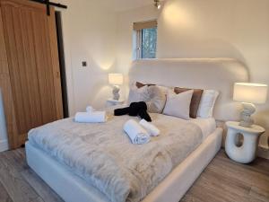 a large white bed with a teddy bear on it at Kaoglen - Alpine Pod - Hot Tub - Cairngorms - Pitlochry in Kirkmichael