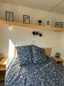 a bedroom with a bed with a blue comforter at Mobil-home 5 personnes in La Baule