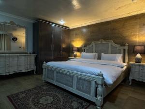 a bedroom with a large bed and a mirror at The Hermitage Cottage-Exclusive Mountain Escape in Murree