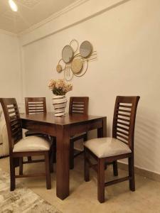 a wooden table with chairs and a vase of flowers on it at Zoe Homes Kericho in Kericho +21 photos