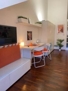 a living room with a desk with a television and chairs at Casa Mirtillo in Turin