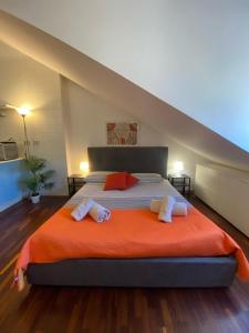 a bedroom with a large bed with an orange blanket at Casa Mirtillo in Turin