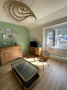 a living room with a couch and a chair and a ceiling at Appartement Le POULIGUEN in Le Pouliguen