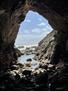a view of the ocean through a rock cave at Appartement Le POULIGUEN in Le Pouliguen