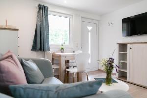 a living room with a couch and a table at Bungalows Ostseequelle in Hohenkirchen +44 photos