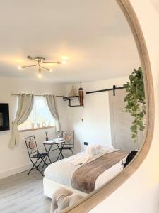 a bedroom with a large mirror on the wall at Kaoglen - Bali Pod - Hot Tub -Cairngorms - Pitlochry in Kirkmichael +64 photos