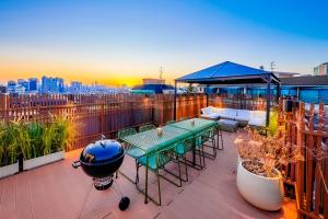 un balcón con una mesa y una parrilla. en Ht Tailored Service Urban Retreat Gym And Garden, en Seúl