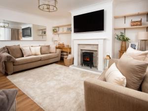 a living room with a couch and a fireplace at Beautiful Alnwick Apartment One in Alnwick