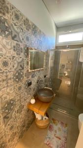 a bathroom with a sink and a mirror at Delizioso appartamento a ridosso del mare del Plemmirio Siracusa in Plemmirio