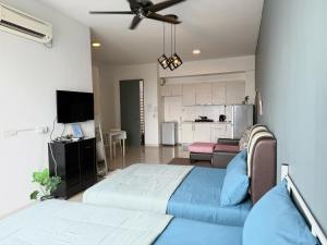 a bedroom with a bed and a living room at Rainforest City House Paradigm Skudai UTM TVBox in Johor Bahru