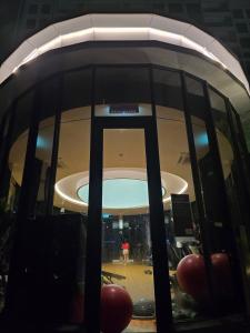 a person holding a cell phone in front of a round window at Trion Kuala Lumpur For KLCC view BLOCK C in Kuala Lumpur