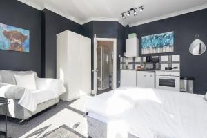 a bedroom with a white bed and a white couch at NEW! Central Studio, Free Parking, WiFi, 5 Min to Train Station in Spon End