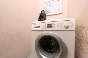 a washing machine with a phone on top of it at Adamou Family House in Prinos