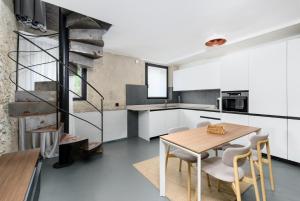 a kitchen and dining room with a wooden table and chairs at VOMAN Luxury Apartments in Pietrasanta