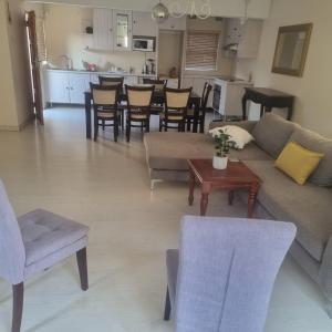 a living room with a couch and chairs and a table at Umsobomvu Guest House in Mthatha