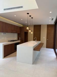 a kitchen with a white counter and wooden cabinets at Luxury Exclusive Villa in Playa del Carmen