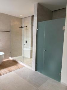 a bathroom with a shower with a glass door at Luxury Exclusive Villa in Playa del Carmen