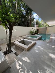 a swimming pool with two sinks in a courtyard with a tree at Luxury Exclusive Villa in Playa del Carmen