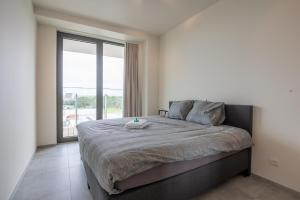 a bedroom with a large bed with a large window at Luxurious new apartment with stunning views in Ostend +26 photos